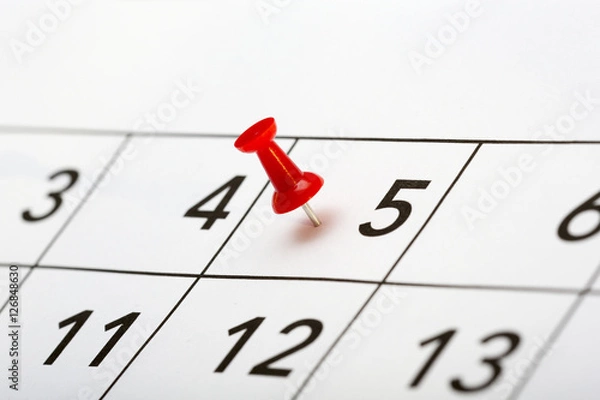 Fototapeta Pin on the date. The fifth day of the month is marked with a red thumbtack. Focus point on the red pin.