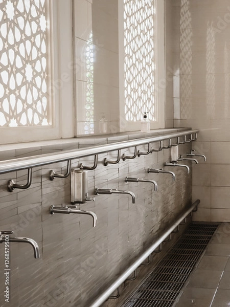 Fototapeta A row of water tap ablution places for Muslims before entrance or praying in the mosque.