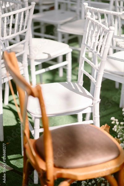 Obraz Brown chair among white chairs that were arranged at weddings that were arranged in gardens and lawns with sunlight and shadow
