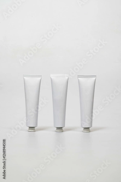 Fototapeta three white tubes on a white table