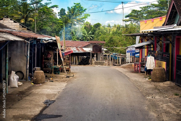 Obraz street in a village in lombok with forest in the background