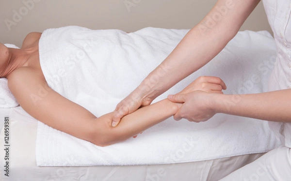 Fototapeta Professional  therapist doing  remedial deep tissue massage on muscles of a woman's  forearm