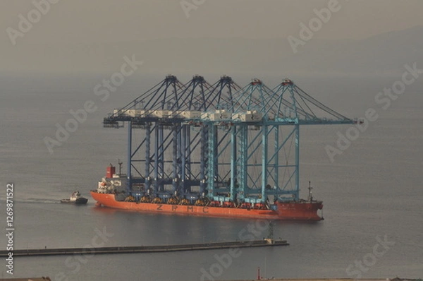 Fototapeta Rijeka, Croatia 17.02.2025. Ship transporting new crain's for Rijeka container terminal. Crain's were deported from China during 70 days of sailing to Rijeka harbour in Europe