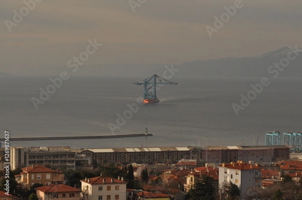 Fototapeta Rijeka, Croatia 17.02.2025. Ship transporting new crain's for Rijeka container terminal. Crain's were deported from China during 70 days of sailing to Rijeka harbour in Europe