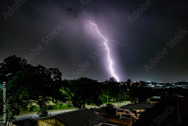 Fototapeta A dramatic photograph capturing powerful lightning strikes illuminating the dark sky. The jagged bolts of electricity contrast against the storm clouds, creating a breathtaking natural spectacle.