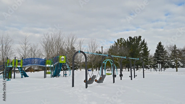 Fototapeta Play equipments covered with snow on the playground in winter