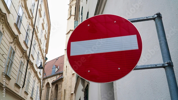 Fototapeta No entry road sign visible on a narrow street in an urban area with historic architecture during daylight