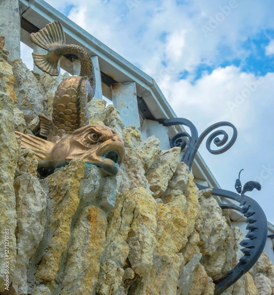 Fototapeta The wall of the ruins of an ancient fortress decorated with a sculpture of a fish