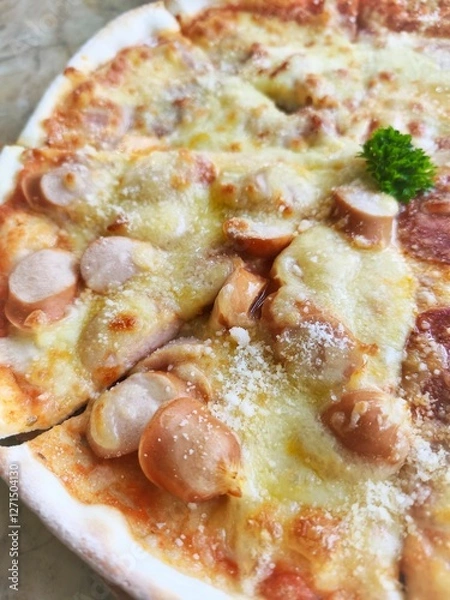 Obraz Crispy thin crust pizza topped with cheese and sausage Italian style, eight pieces placed on a wooden tray.