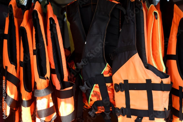 Fototapeta Row of Life Jackets Hanging on Rack for Safety