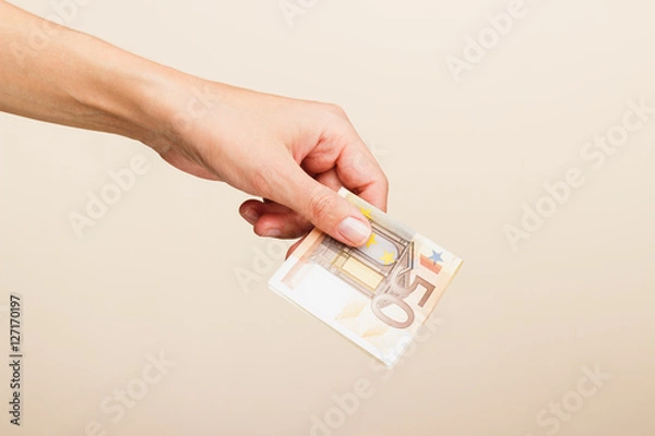 Fototapeta Woman's hand with money on a light background