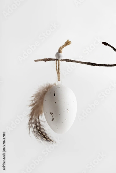 Fototapeta Easter composition in natural colours  with decorative egg hanging on a twig. Easter background and wallpaper.