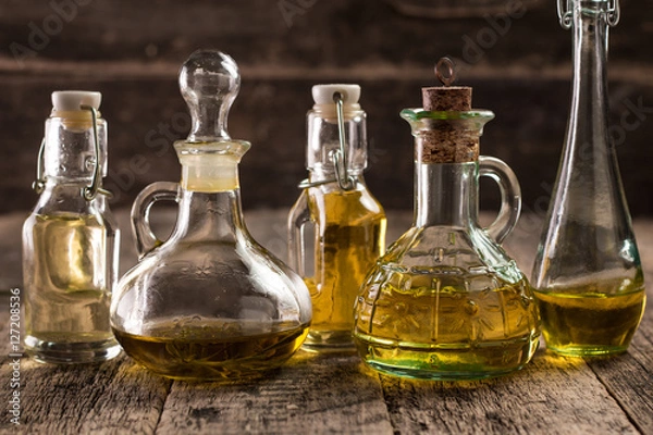 Obraz Assortment of spicy sunflower,corn,sesame seeds ,avocado ,grape seeds oils with herbs and spices in different bottles on wooden background