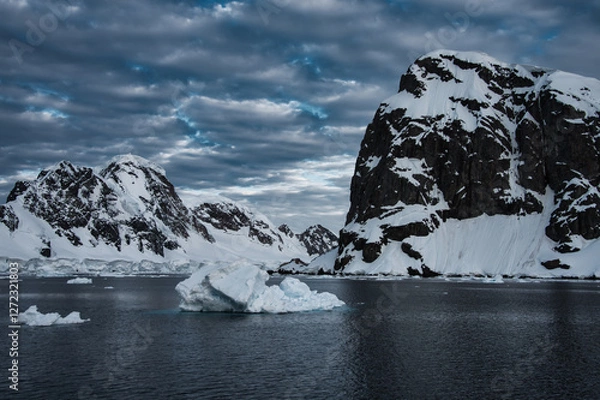 Fototapeta Antarctic Peninsula: Snowy peaks, icebergs, cloudy sky. Lemaire Channel