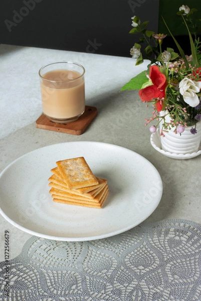 Obraz a glass of milk tea with biscuits on a plate