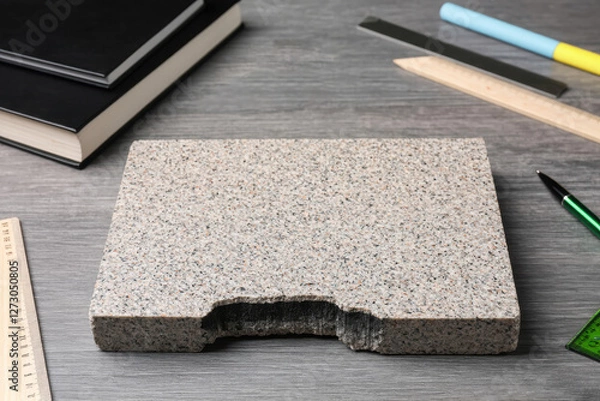 Obraz A granite stone lies on the student's desk, next to books, a pen, a calculator, a protractor, the concept of gnawing the granite of science
