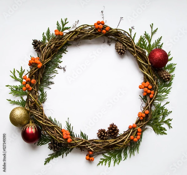 Fototapeta Christmas wreath of vines with decorative ornaments, thuja branches, rowanberries and cones. Flat lay, top view