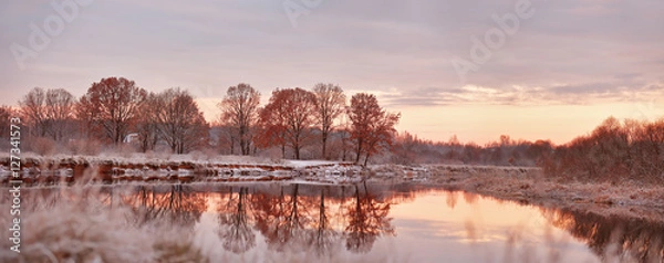 Fototapeta Cloudy and sunny autumn dawn. First snow on the autumn river. Oa