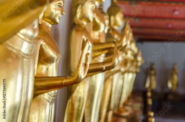 Fototapeta Golden Buddha statues in a serene setting