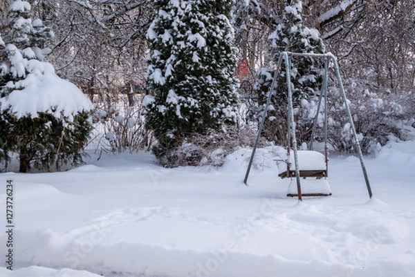 Fototapeta snow-covered swings in the yard with deep snow
