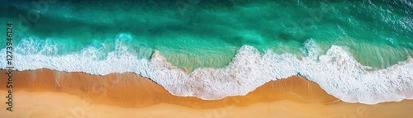 Fototapeta Aerial view of a sandy beach meeting turquoise ocean waves.