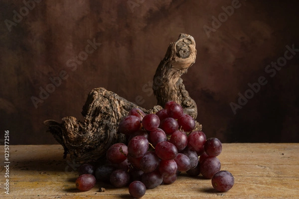 Fototapeta Top view of bunch of red grapes on vine trunk, dark background, horizontal with copy space