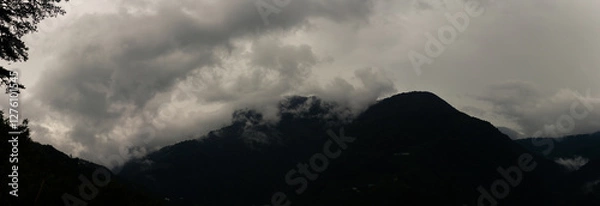 Fototapeta Dark Storm Clouds Swirling Around Towering Mountain Peaks Creating a Dramatic and Mysterious Atmosphere in Taiwan