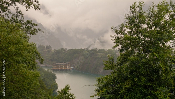 Fototapeta Floating Structure on Misty Mountain Lake Surrounded by Lush Greenery and Steep Cliffs in Taiwan’s Remote Wilderness