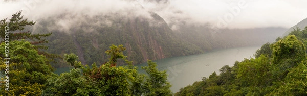 Fototapeta Misty Mountain Cliffs Towering Over Serene Emerald Lake Surrounded by Lush Greenery in Taiwan’s Remote Wilderness