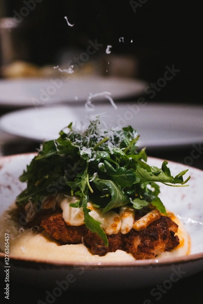 Obraz Close Up Chicken Parmigiana With Mashed Potatoes Covered With Fresh Arugula And Topped With Cheese