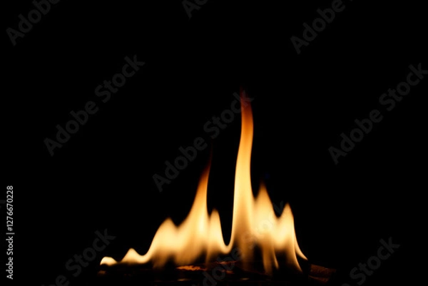Fototapeta Flames Dancing on a Dark Background Creating a Warm Atmosphere