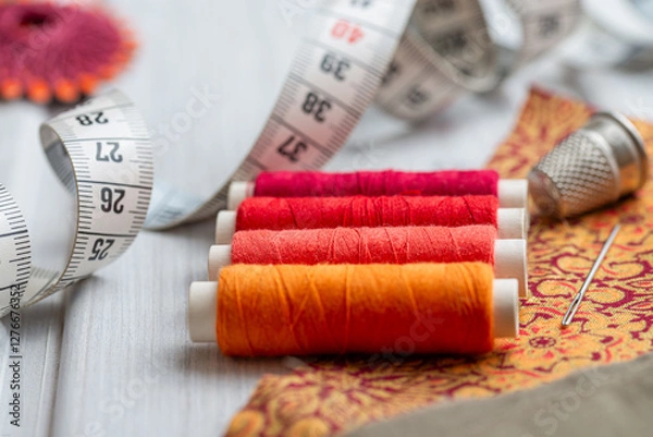Obraz Sewing kit - colorful yarns, fabric, needle and measuring tape on white wooden table