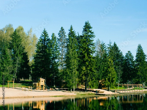 Fototapeta modern wooden playground on the lake shore