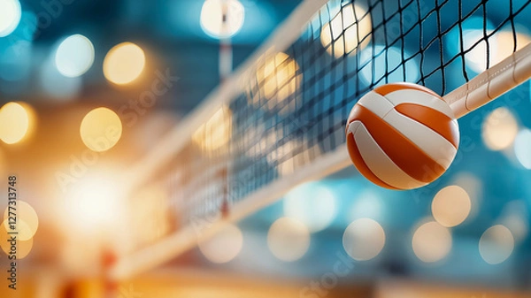 Fototapeta close up of volleyball near net, with blurred background of lights creating vibrant atmosphere. scene captures excitement of game
