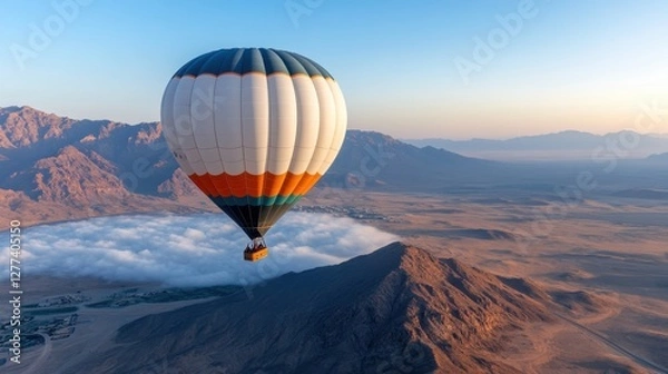 Fototapeta Hot air balloon floats above clouds in Murqquab desert at dawn