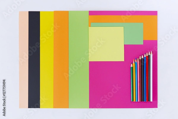 Fototapeta Colored paper and colored pencils on white background.