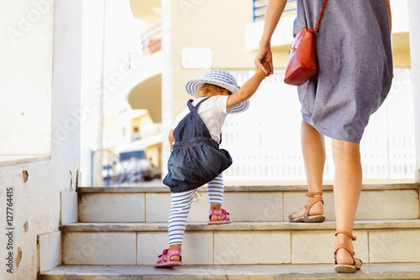 Obraz Back view of beautiful toddler girl walk with mother, stairs outdoors background, closeup view