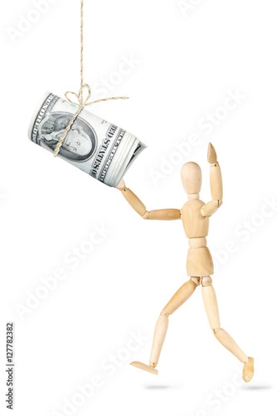 Fototapeta Man wants to catch a roll of dollars banknotes hanging above. Abstract image with a wooden puppet