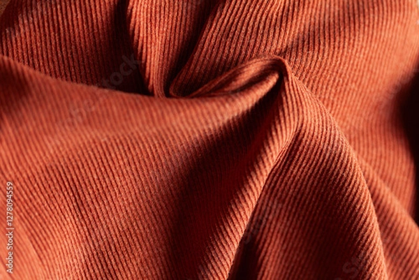 Fototapeta Close-up of textured fabric with linear patterns and warm, earthy tones, showcasing folds and surface details.