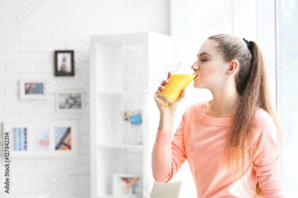 Obraz Młoda piękna kobieta pije sok