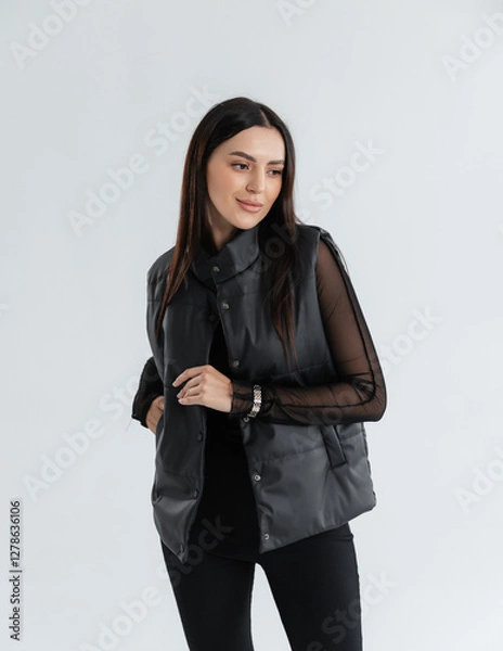 Fototapeta Portrait of a cute girl model in a black vest and pants on a white background in the studio