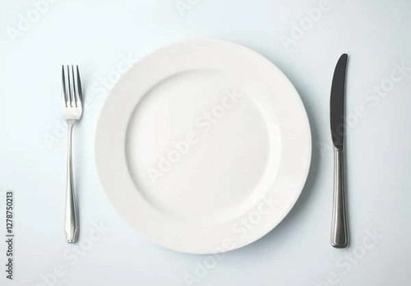 Fototapeta White plate with knife and fork on a white background, top view.