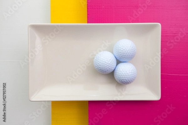 Fototapeta White ceramic dish with golf balls