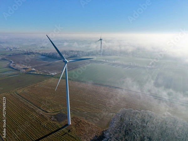 Fototapeta Aerial view of wind turbines in a winter landscape with sun and deep fog over the fields, wind energy, renewable energies, energy transition, climate protection