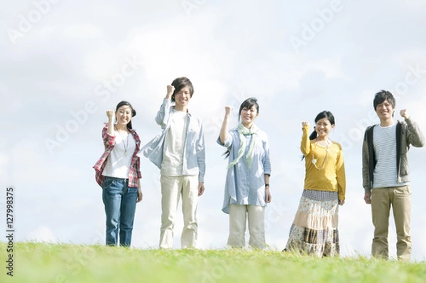 Fototapeta 草原でガッツポーズをする若者たち