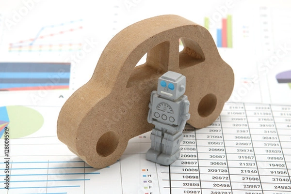 Fototapeta Business concept with miniature robot, car model, and financial graphs