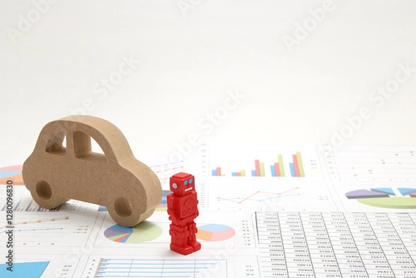 Fototapeta Business concept with miniature robot, car model, and financial graphs