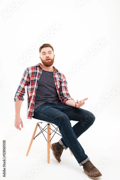 Fototapeta Man talking and gesturing hand while sitting on the chair