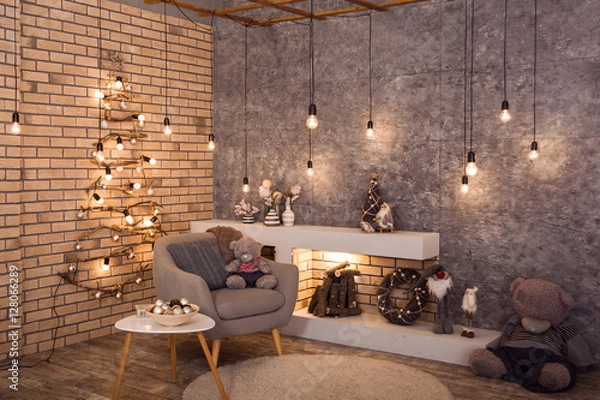 Obraz Winter loft style room decorated with original wodden Christmas tree, bulbs kight garland. Firewood are burning in contemporary scandinavian fireplace. Horizontal