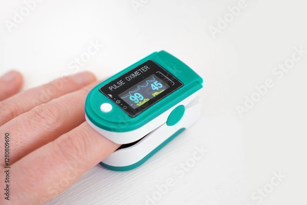 Obraz Pulse oximeter used to measure pulse rate and oxygen levels with hand.